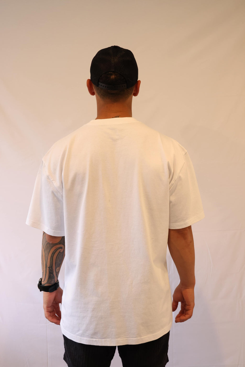 Person wearing a plain white t-shirt against a grey background