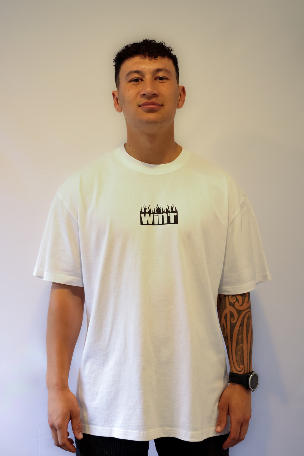 Person wearing a white Winr heavyweight t-shirt with black logo, premium cotton streetwear tee against a plain background.
