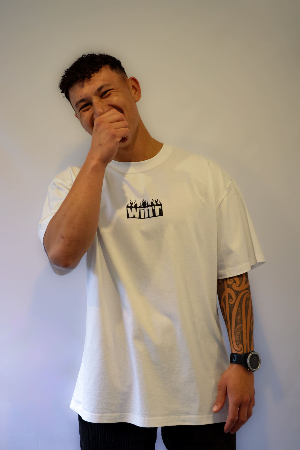 Person wearing a white Winr heavyweight t-shirt with black logo, standing against a plain background.