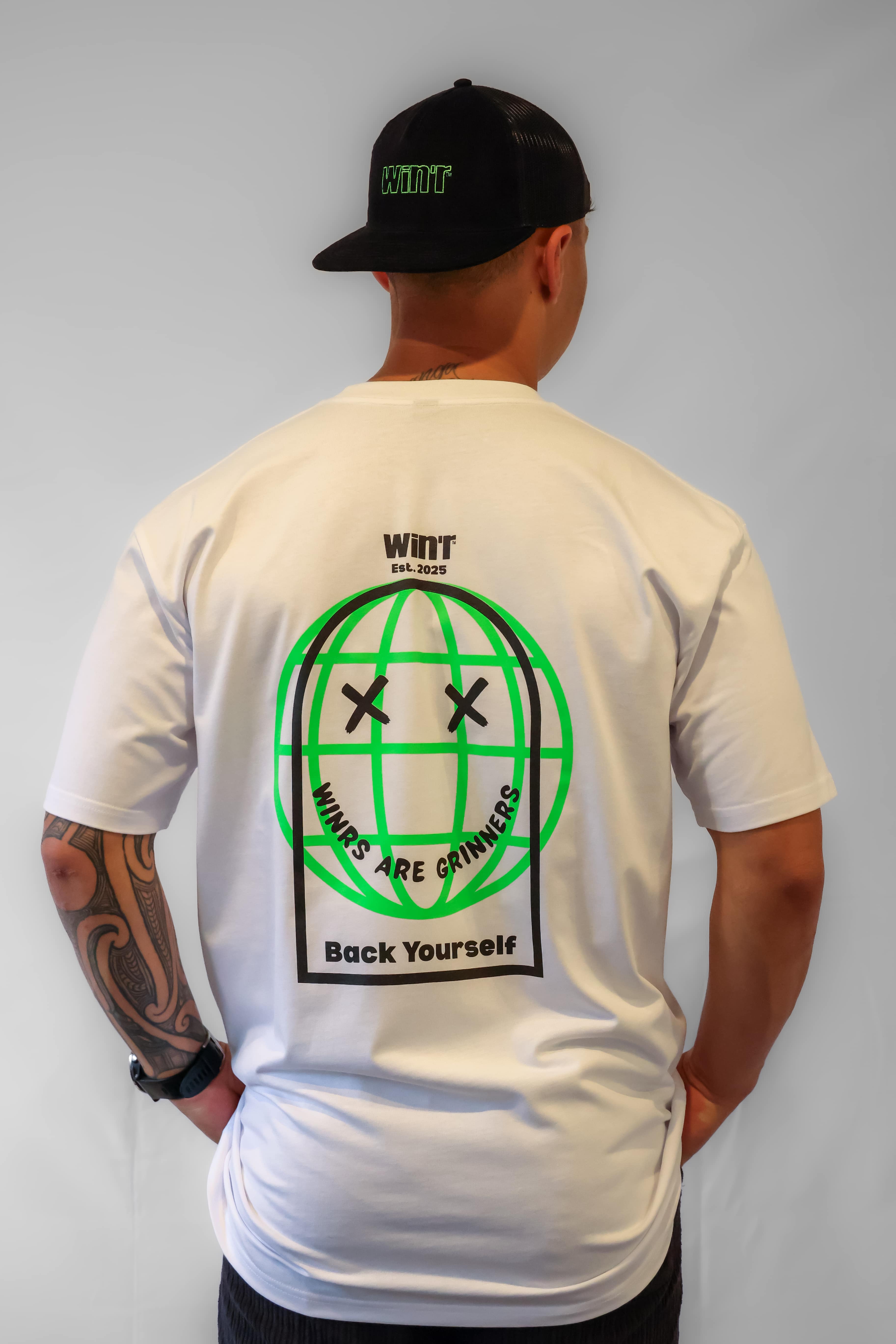 Person wearing a white Winr print t-shirt with green and black graphic design on the back, premium cotton streetwear tee against a plain background.