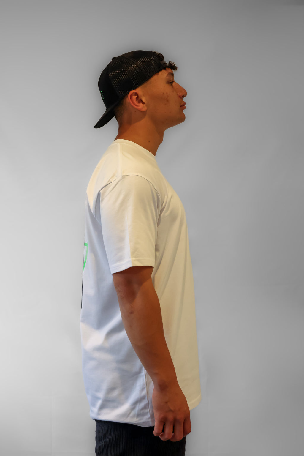 Person wearing a white Winr t-shirt and black cap against a grey background