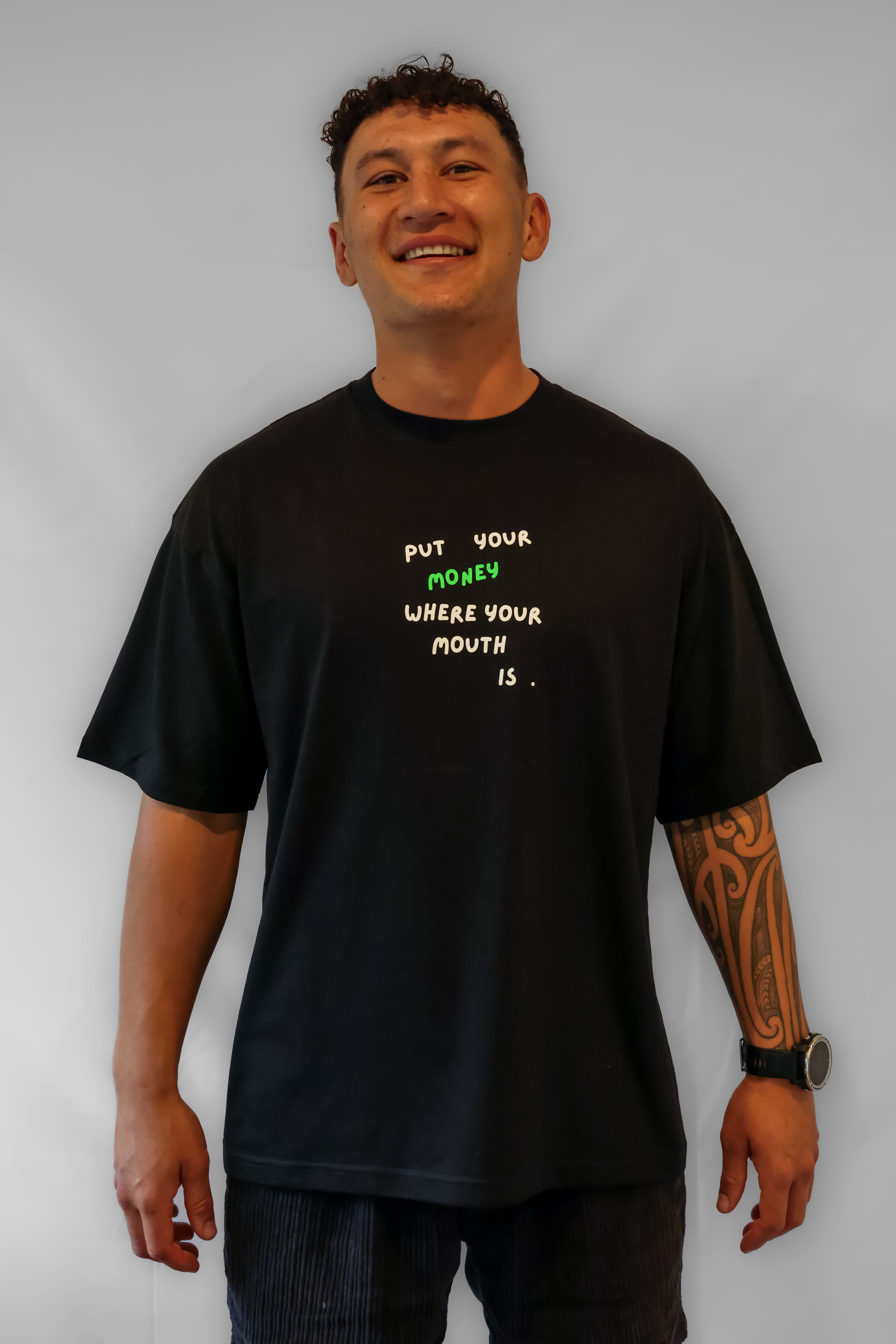 Man wearing a black oversized Winr t-shirt with bold text graphic, premium cotton streetwear tee against a plain background.